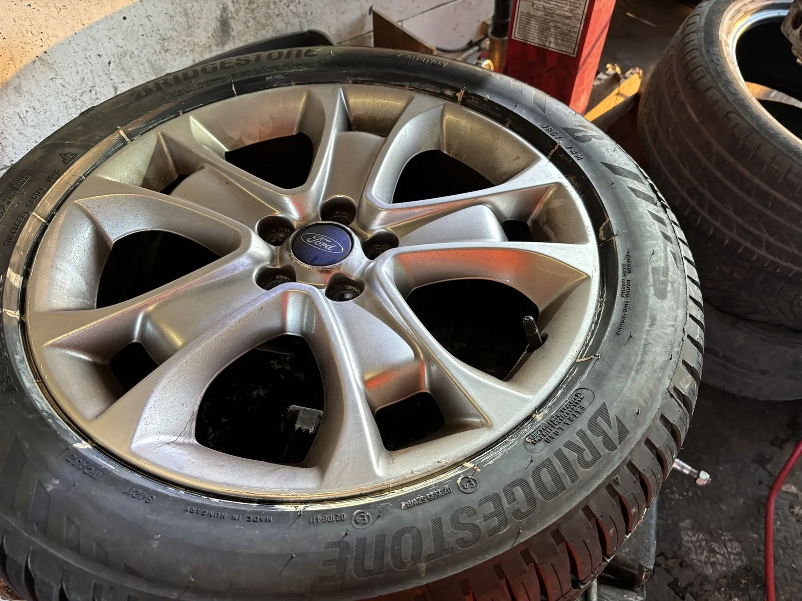 A Ford alloy wheel with a Bridgestone tyre ready to be inspected and repaired